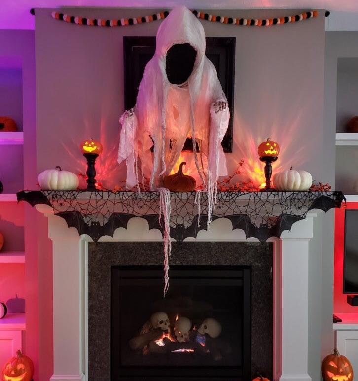 Ghost decoration over Halloween-themed fireplace mantel