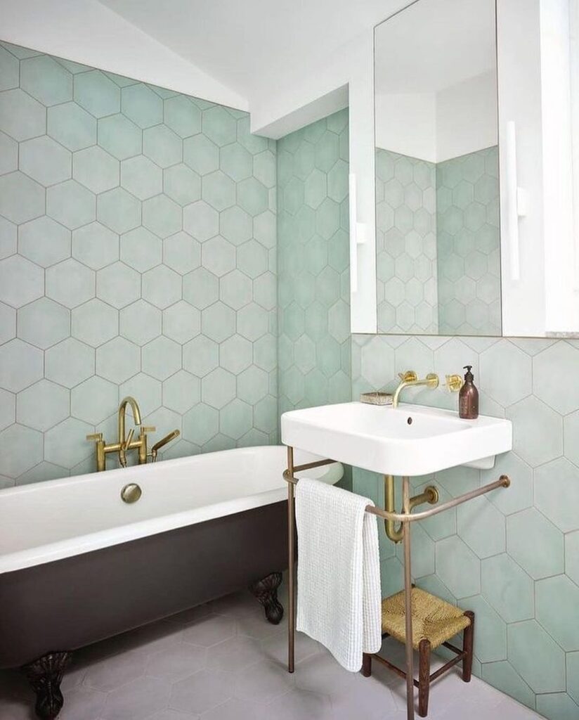 Sage hexagon tiled bathroom with clawfoot tub and brass fixtures