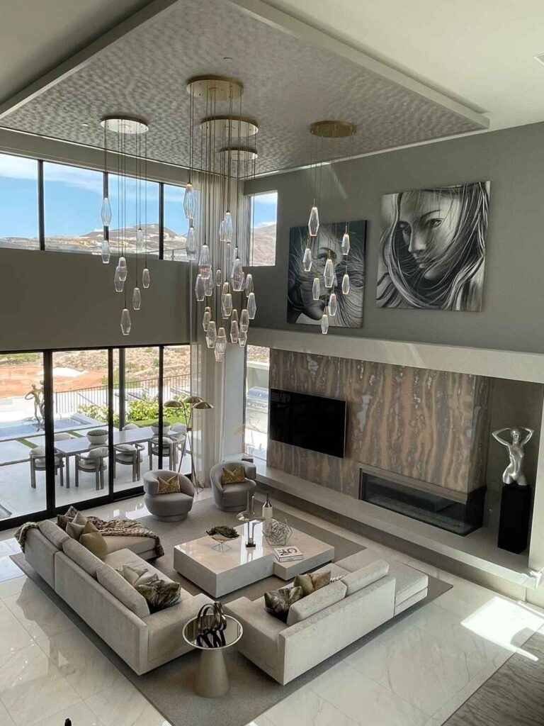 Elegant living room with mountain view and hanging light fixtures.