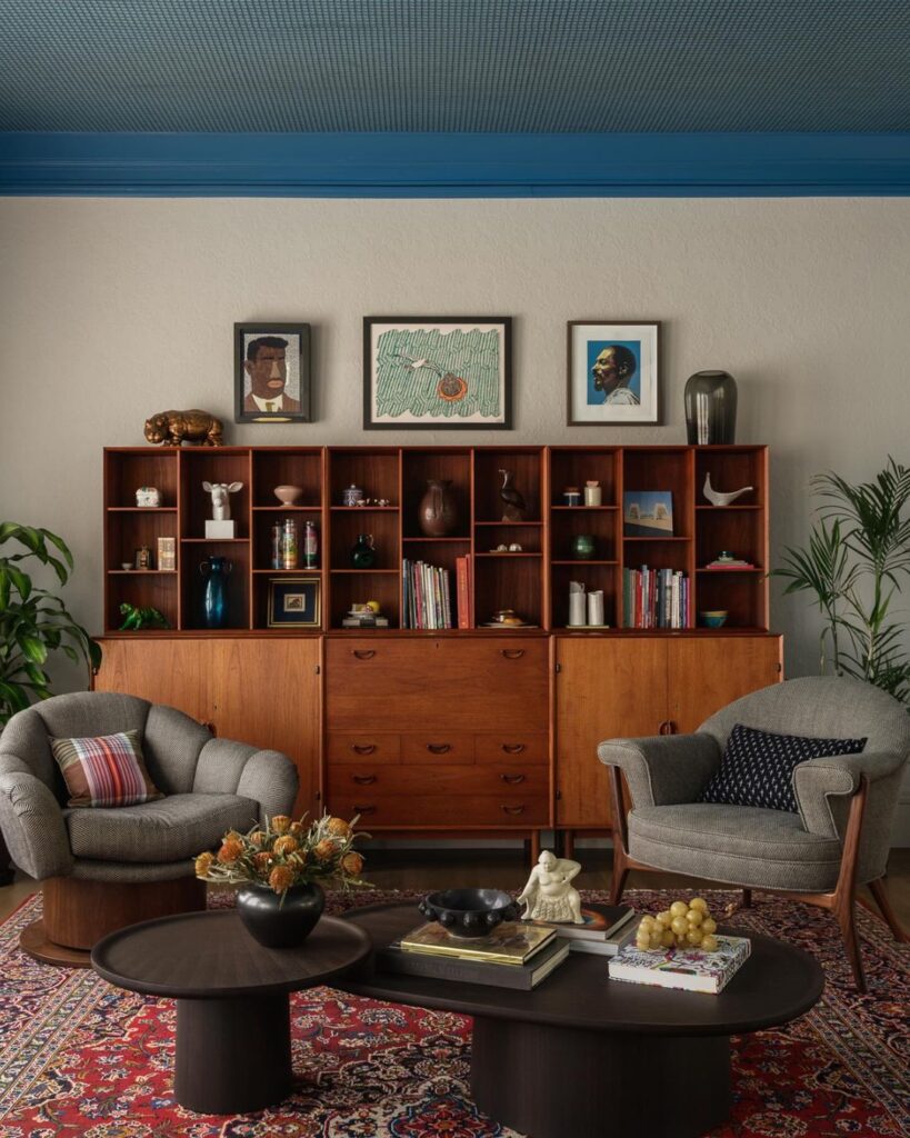 Cozy mid-century living room with wooden shelving and artistic decor.