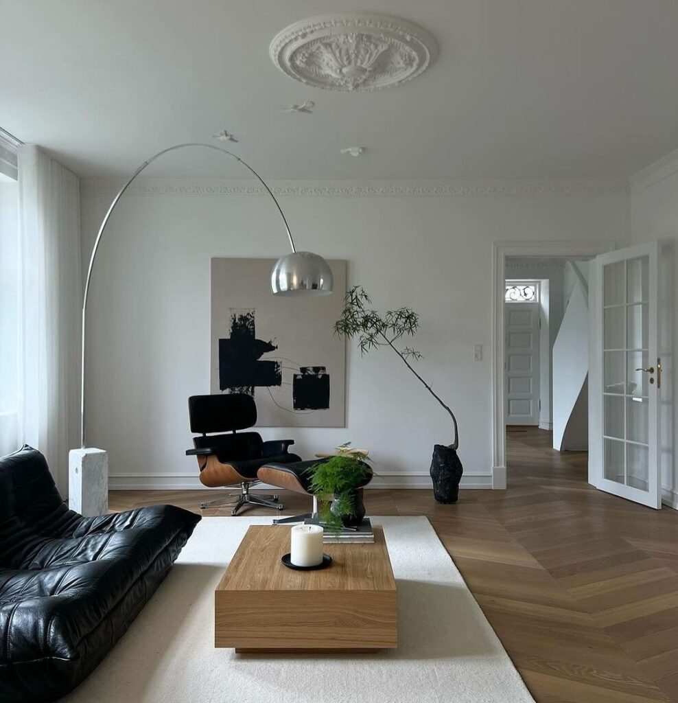 Minimalist living room with Eames chair and arching lamp.