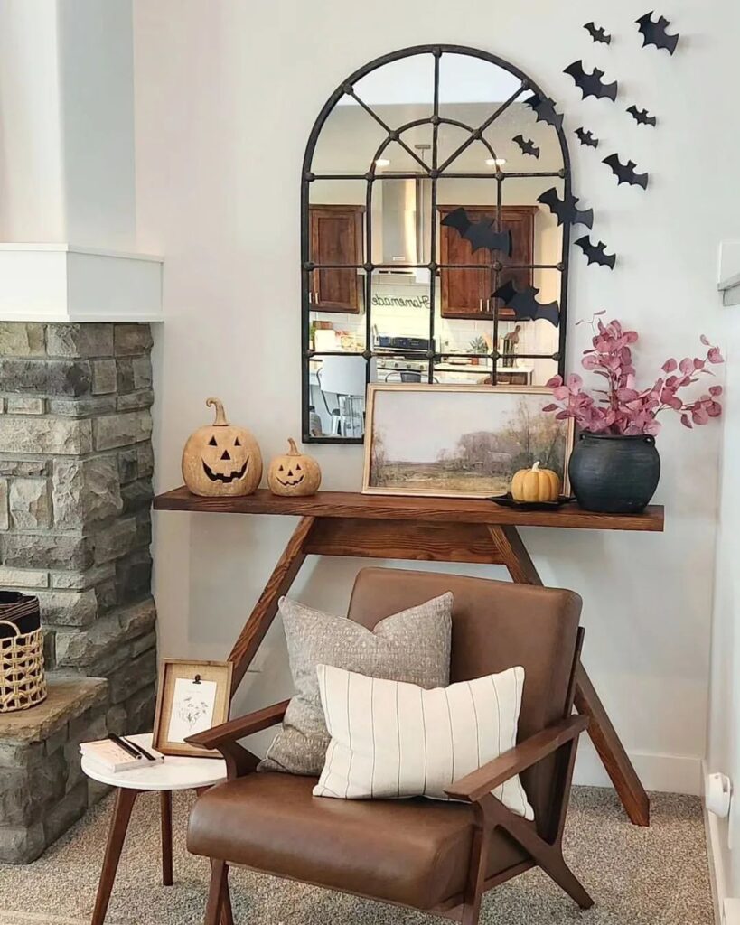 Modern living room corner with Halloween decor and arched mirror.