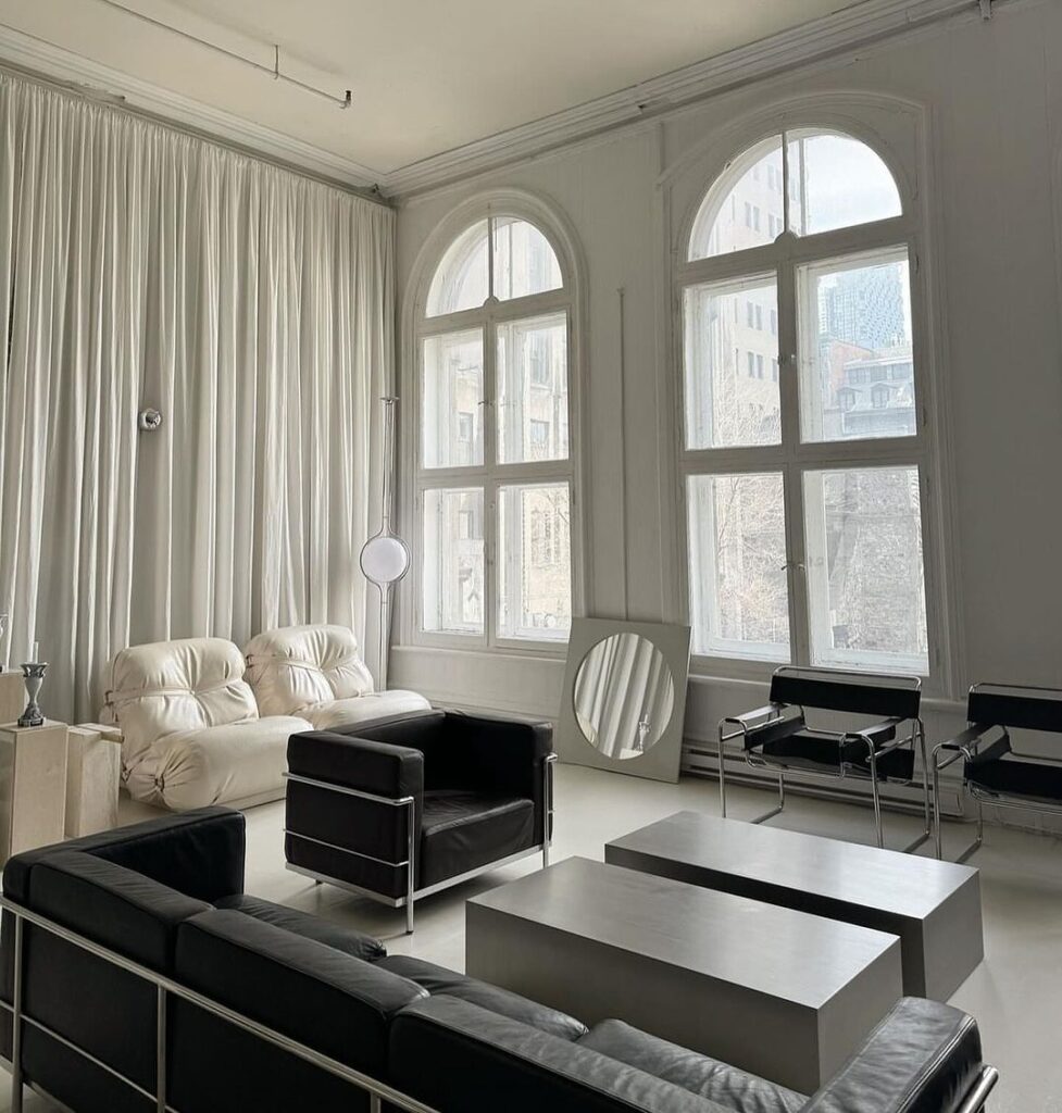 Minimalist living room with arched windows and black-white decor.