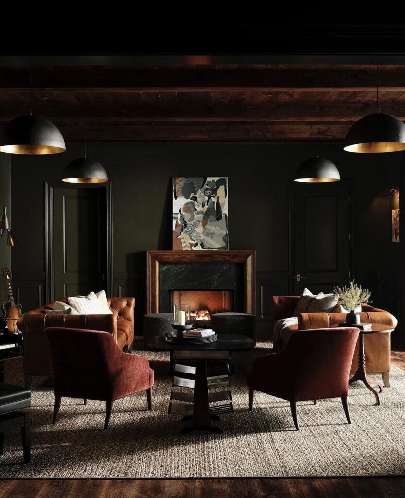 Dark living room with leather sofas fireplace and pendant lights.