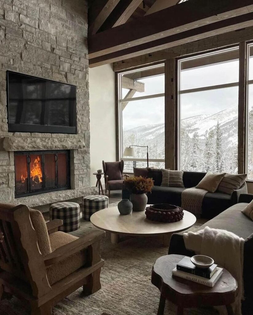 Cozy living room with stone fireplace and panoramic mountain view.