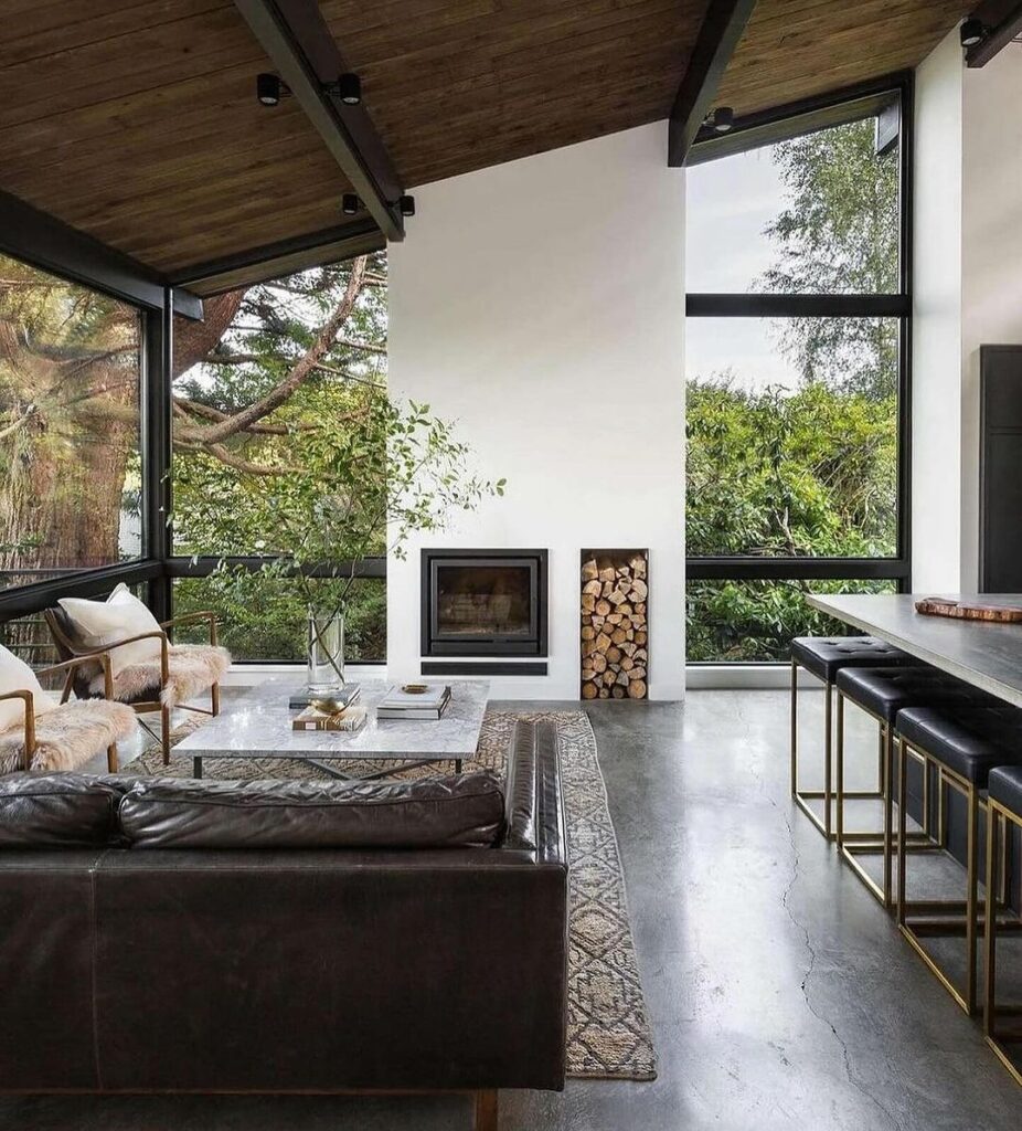 Modern living room with panoramic forest views.