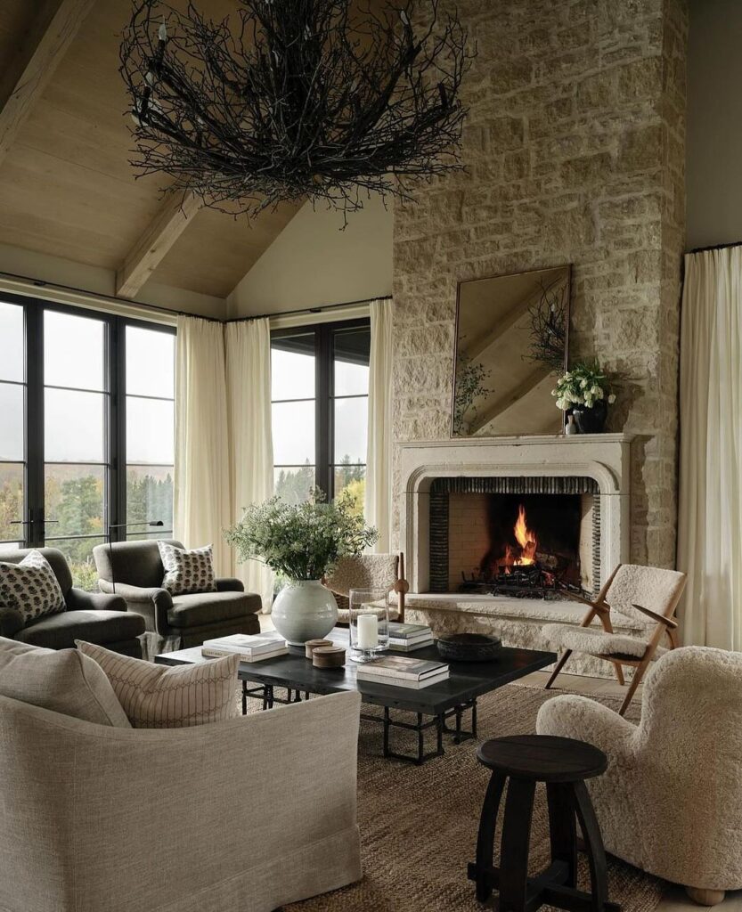 Rustic living room with stone fireplace twig chandelier and panoramic windows