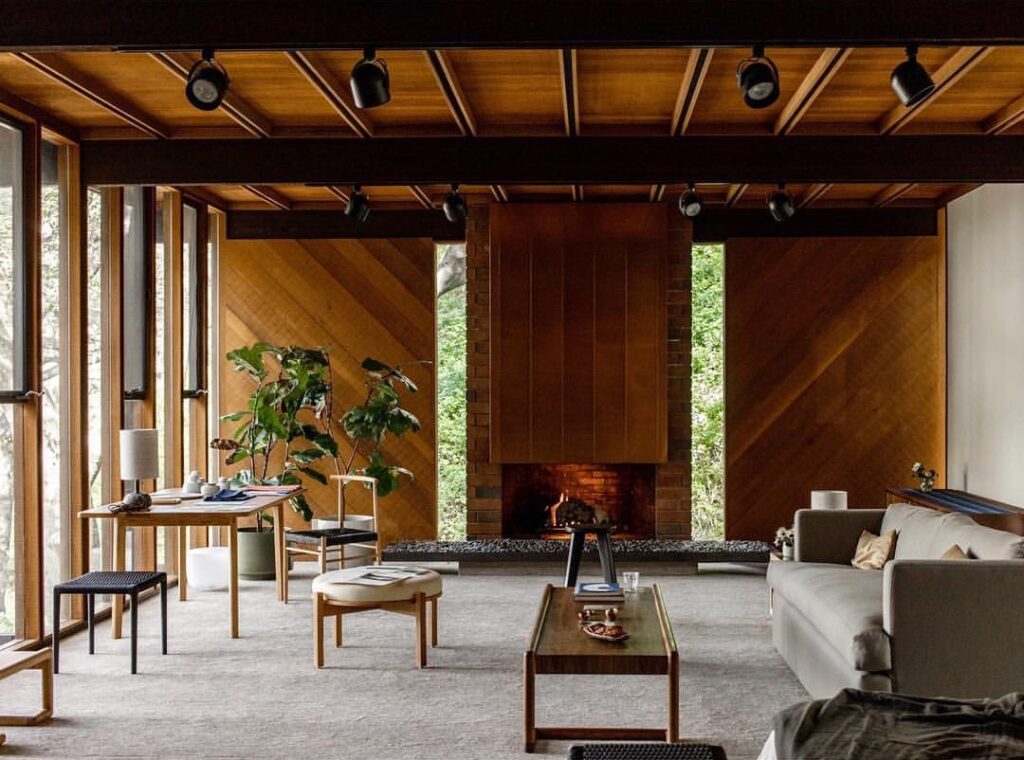 Mid-century living room with wood paneling and large windows