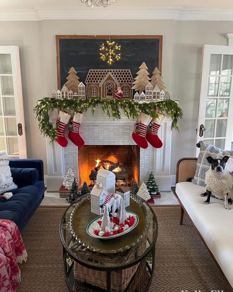 Festive fireplace with wooden gingerbread village mantel and evergreen garland