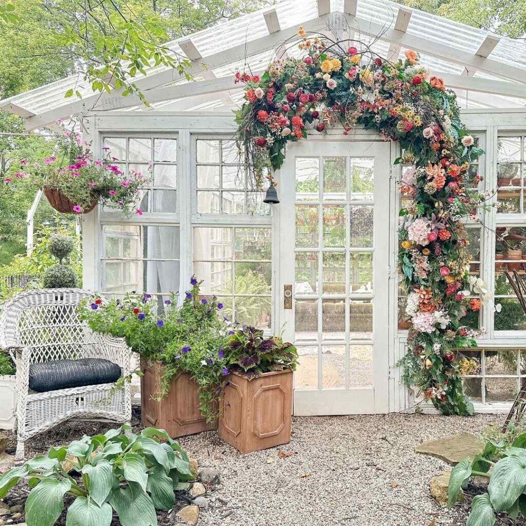 Vintage white greenhouse doorway adorned with cascading floral arch