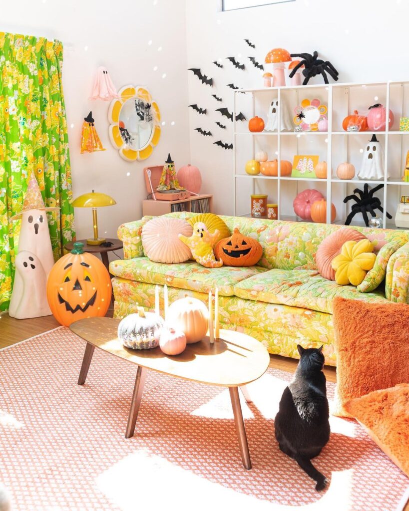 Pastel-colored living room with cute Halloween decorations and a cat.