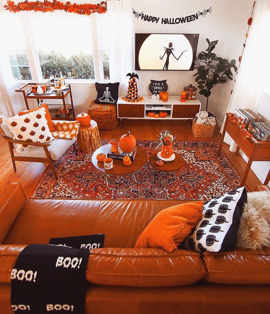 Halloween-themed living room with orange decor and pumpkins