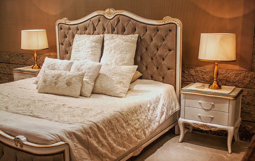  "Cream Victorian bedroom with tufted headboard and golden accents"