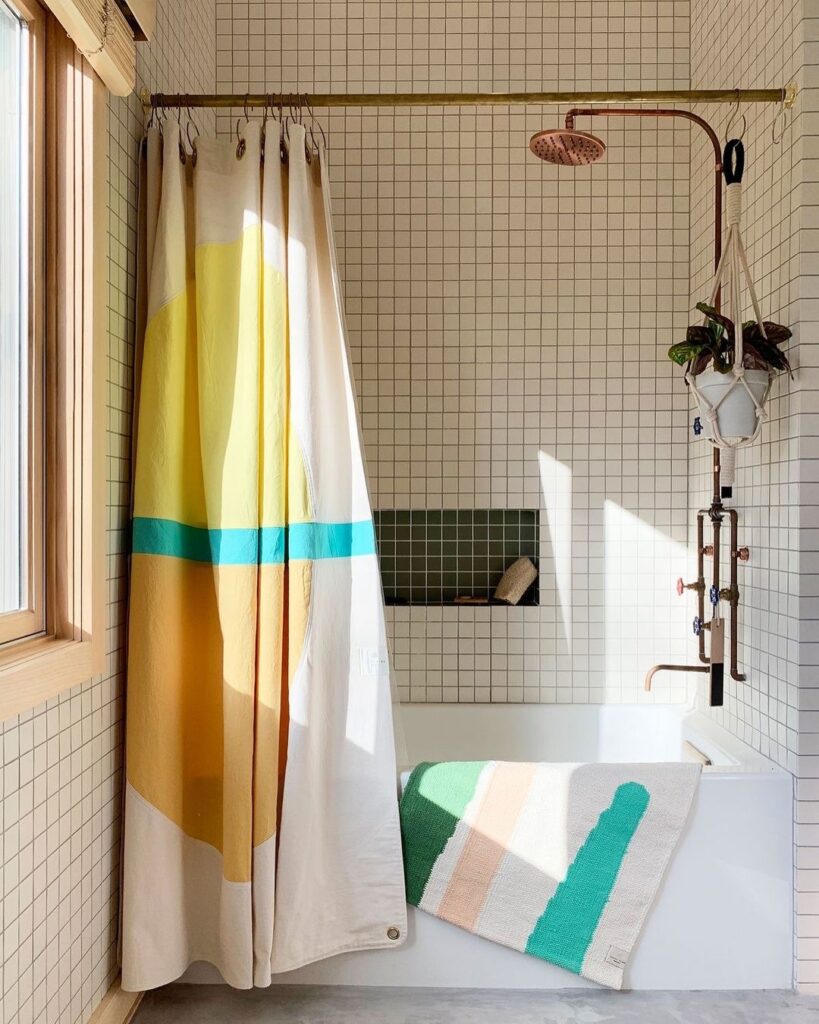 Bathroom with geometric shower curtain and matching bath mat