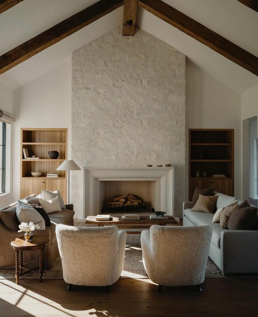 Cozy living room with vaulted ceiling limestone fireplace and neutral furniture