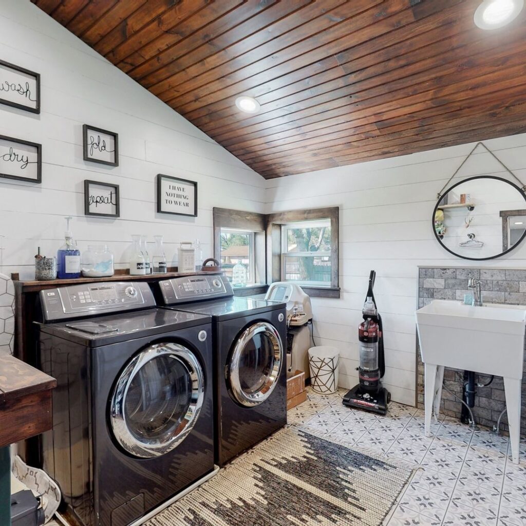 Spacious laundry room with wooden ceiling and modern appliances.