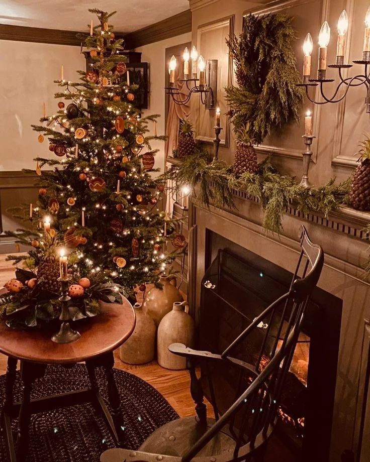 Colonial Christmas tree with dried orange slices beside vintage fireplace and Windsor chair