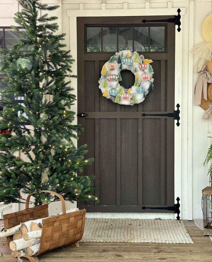 Craftsman door with village wreath and lit Christmas tree