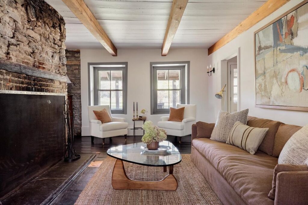 Bohemian living room with stone fireplace and exposed beams.
