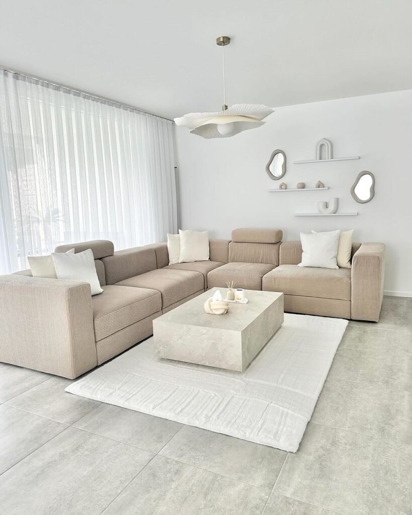 Minimalist living room with beige sectional and concrete table.