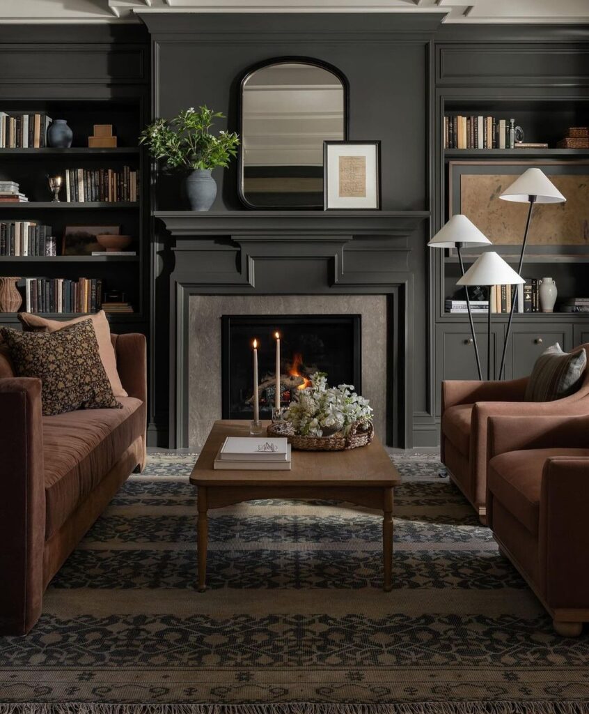 Dark living room with built-in bookshelves fireplace and brown sofas