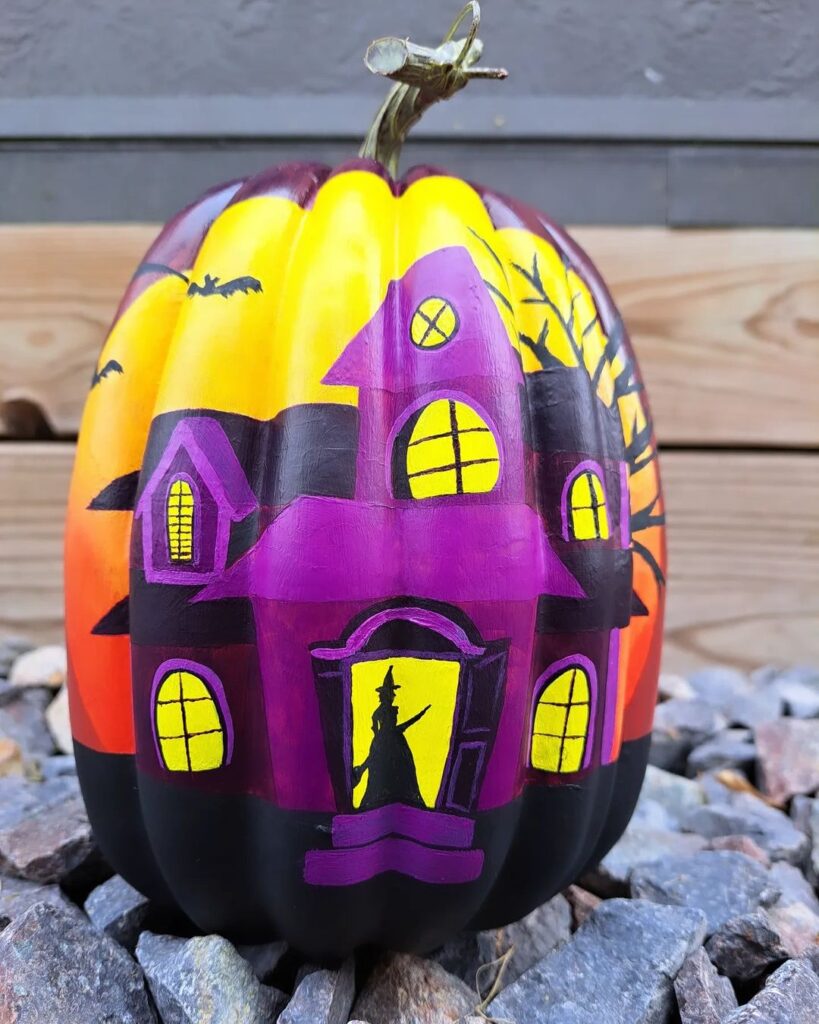 Painted pumpkin featuring haunted house and Halloween scene.