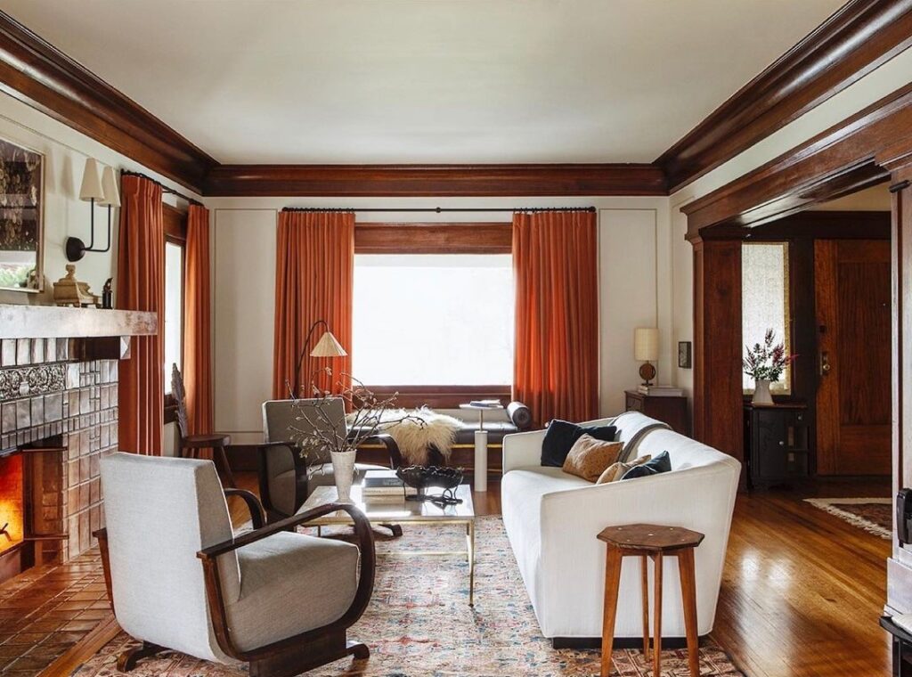 Mid-century living room with white sofa and orange curtains