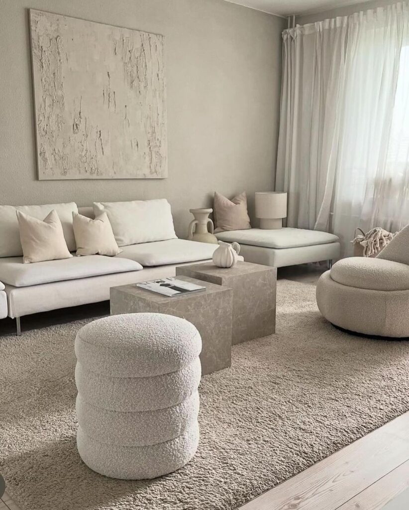 Minimalist cream living room with textured furnishings and art.