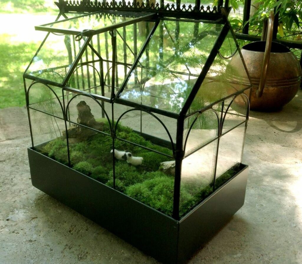 Ornate glass terrarium with mossy landscape inside