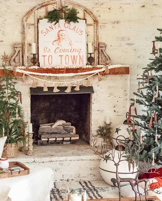 Rustic farmhouse fireplace with vintage Santa sign and boho Christmas decor