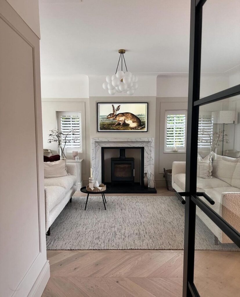 Bright living room with hare painting above fireplace