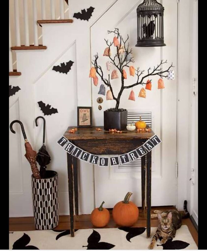 Halloween-decorated entryway with treat tree and pumpkins