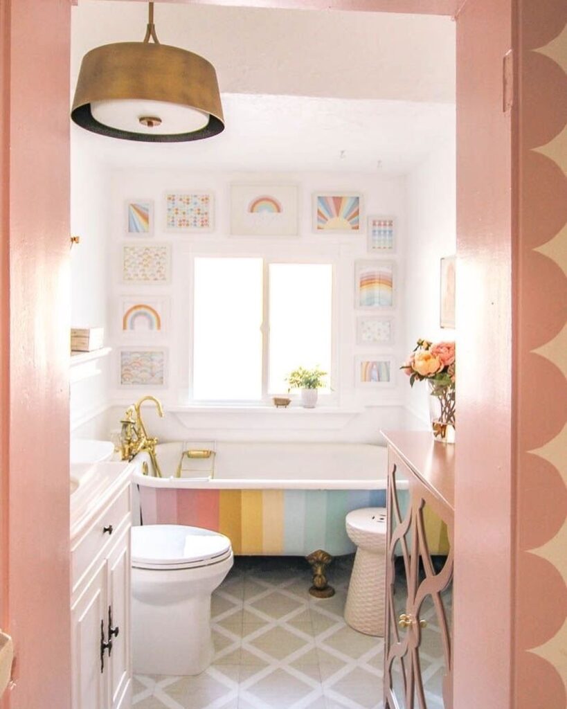 Pastel bathroom with rainbow striped tub and colorful artwork