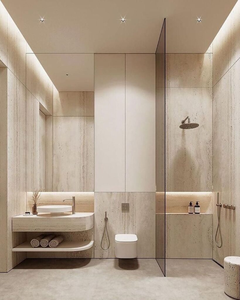 Minimalist beige bathroom with textured walls and hidden lighting. 