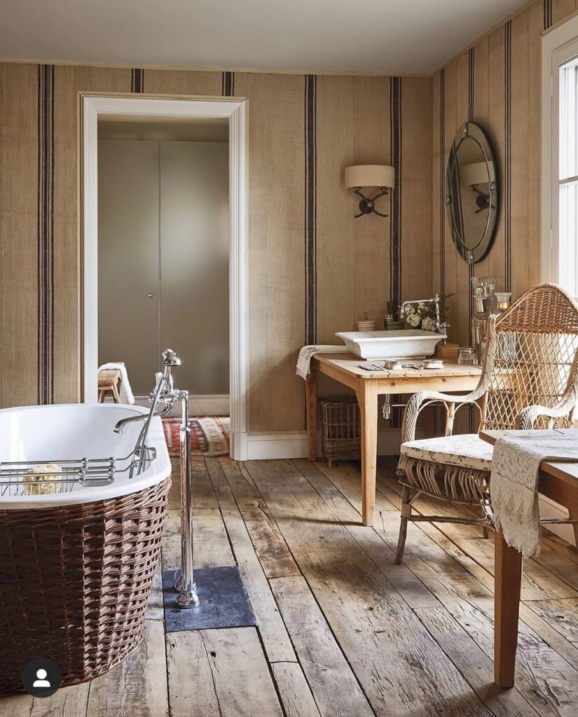 Rustic bathroom with woven bathtub and wooden vanity featuring striped wallpaper