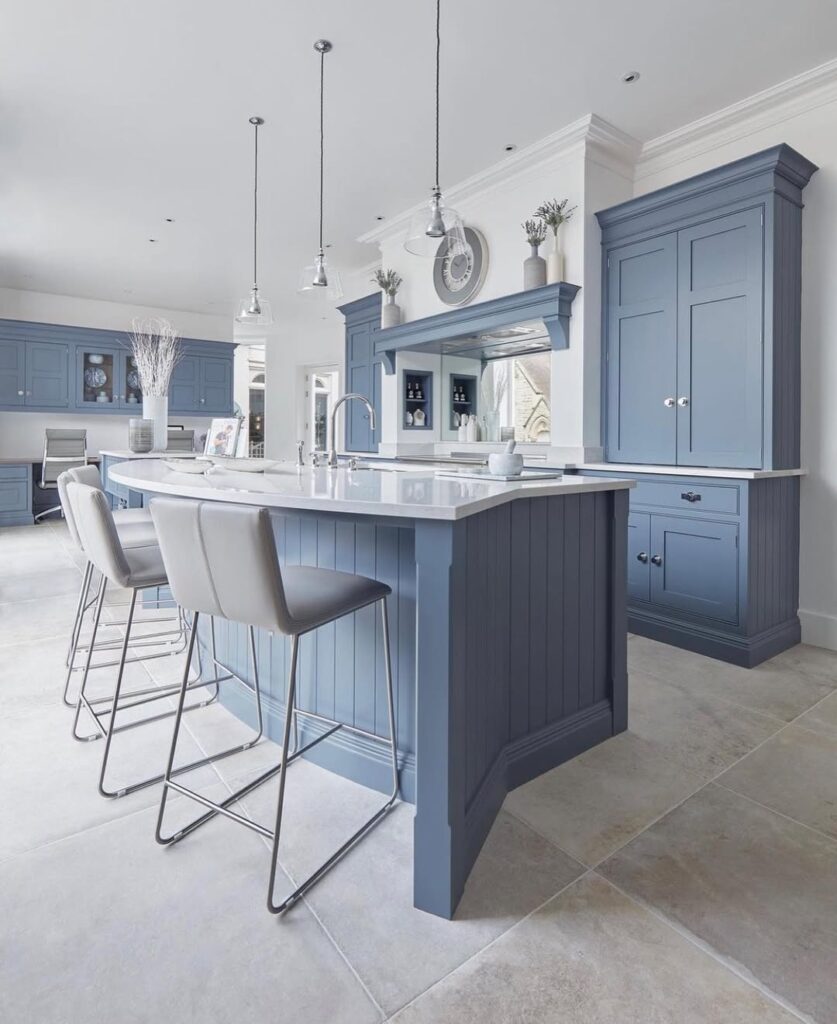 Modern kitchen with light blue cabinets white countertops and chrome pendant lighting