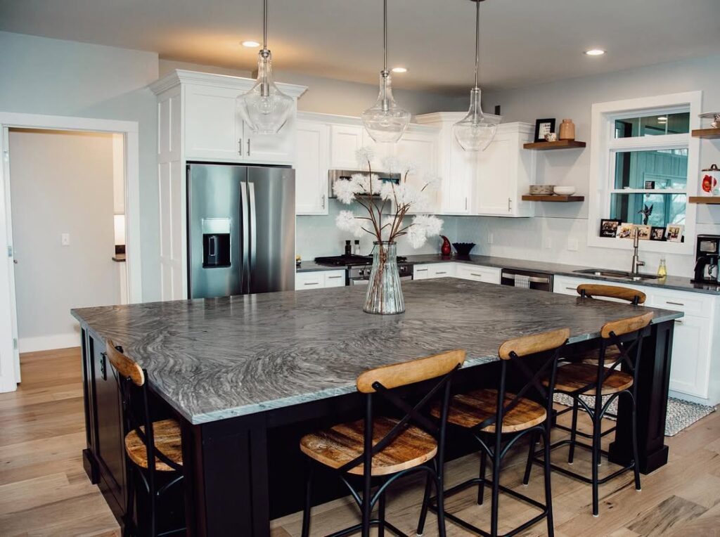 Kitchen with grey swirled granite countertop and glass pendant lights