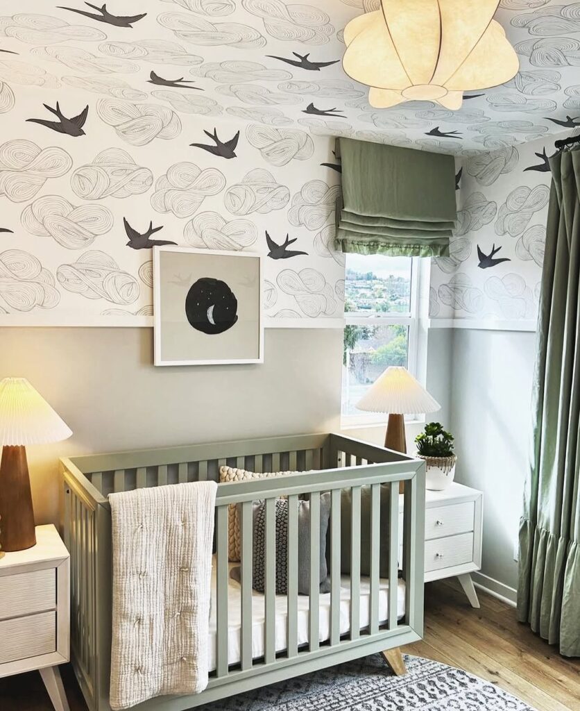 Nursery with bird wallpaper sage green crib and modern lighting fixtures