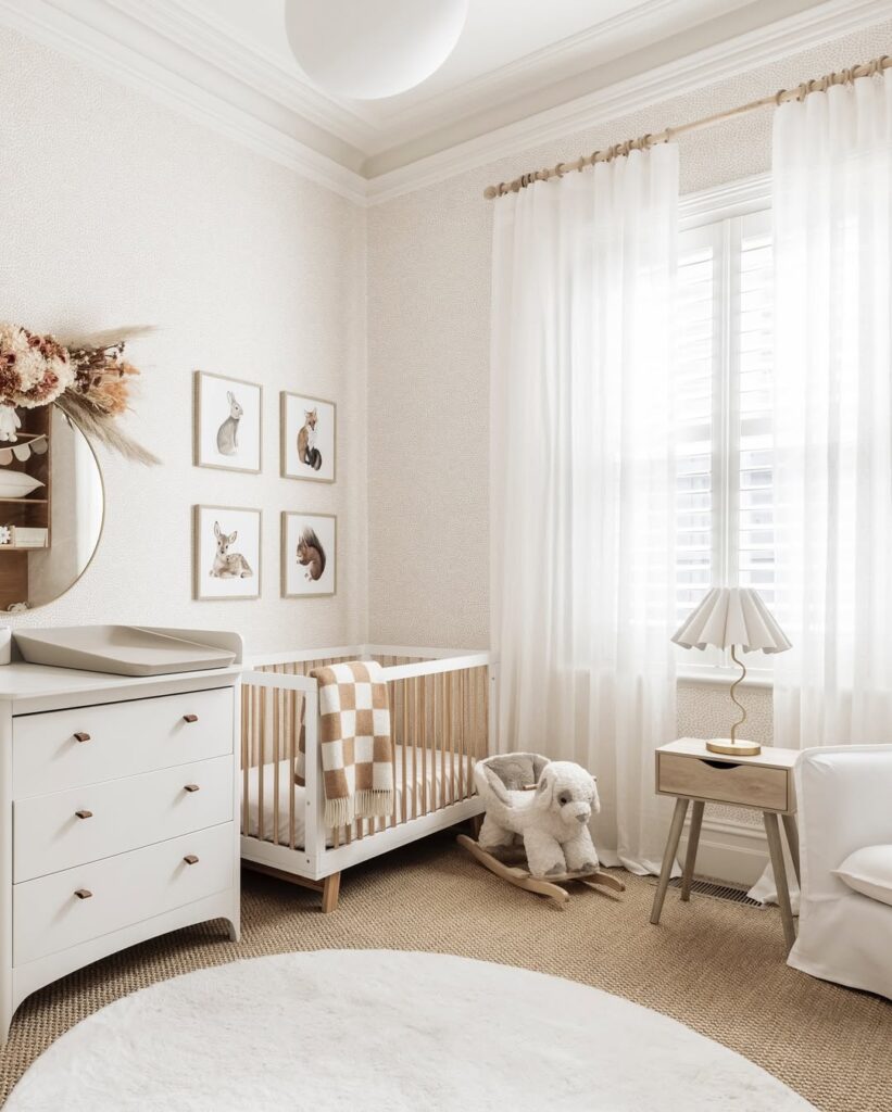 Neutral nursery with woodland prints and white furniture