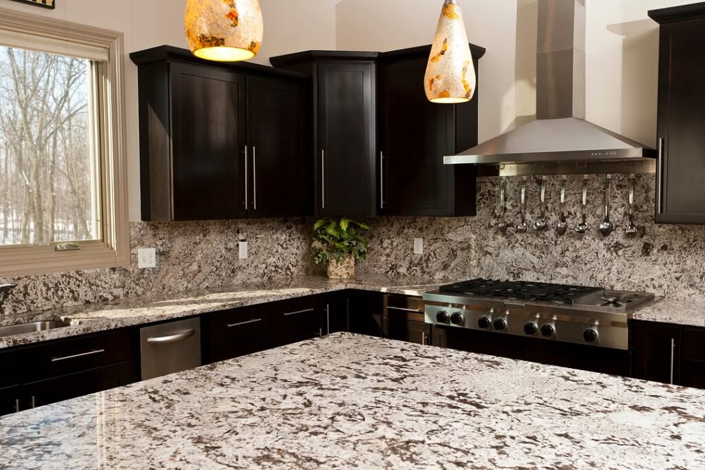 Modern kitchen with black cabinets granite countertops and amber pendant lights