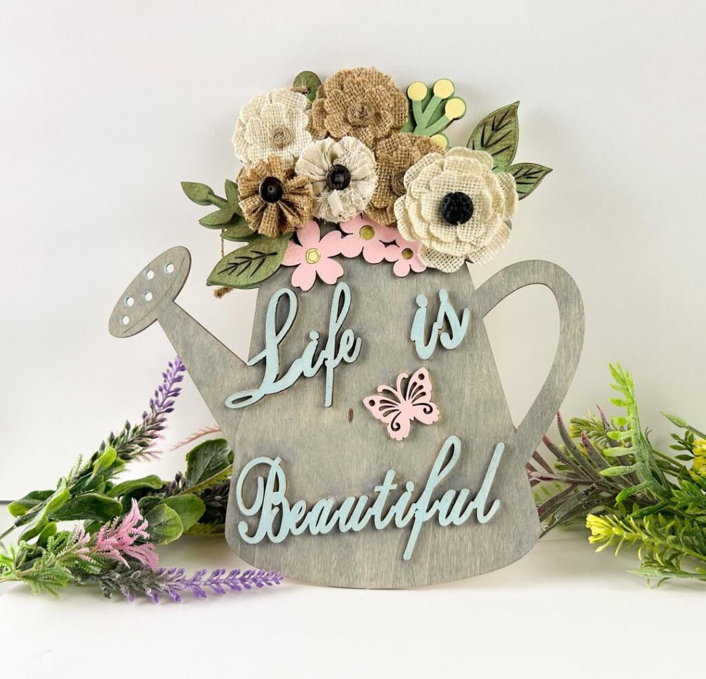 Grey watering can wall decor with burlap flowers and inspirational text