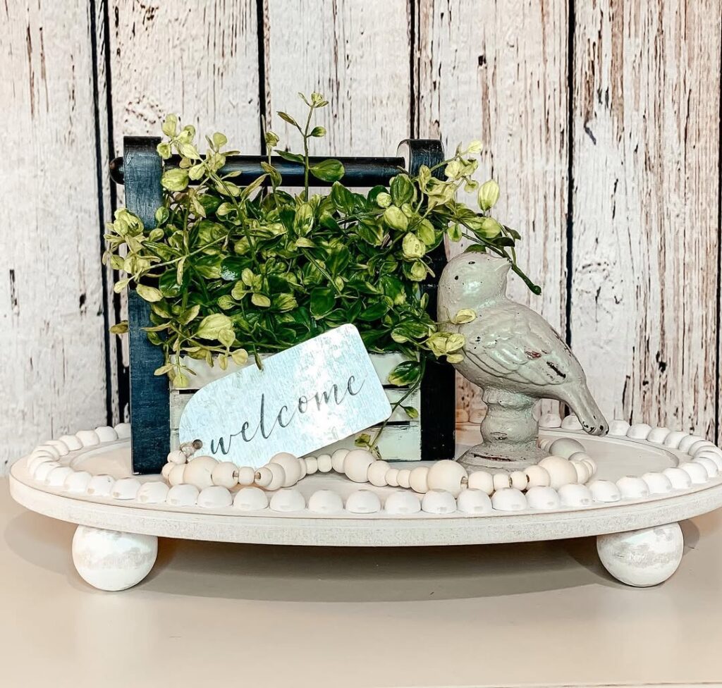 White beaded tray with wooden crate greenery and decorative bird