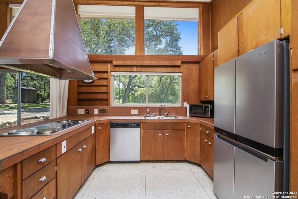 Original mid century kitchen with wood cabinets and large windows