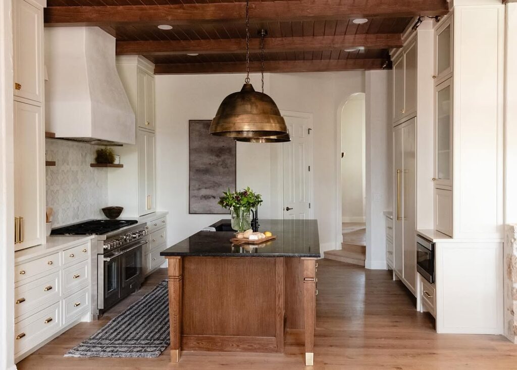 Kitchen with wooden beams copper pendant and patterned tile backsplash