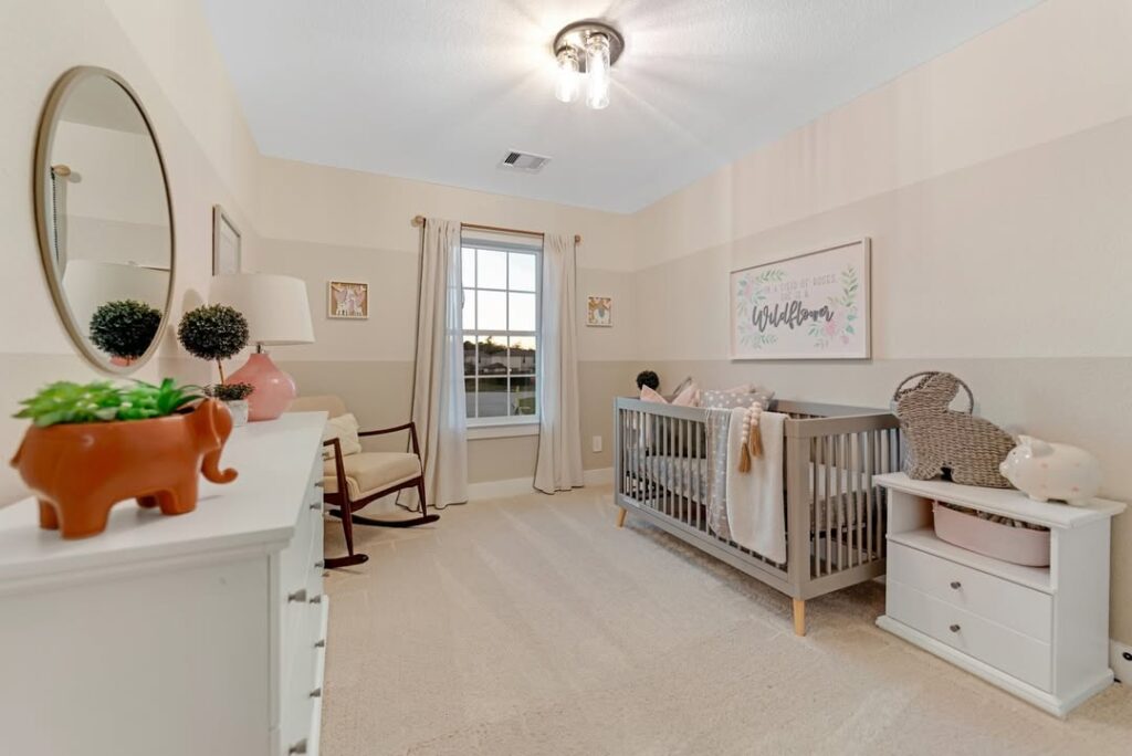 Modern nursery with striped walls grey crib and rocking chair