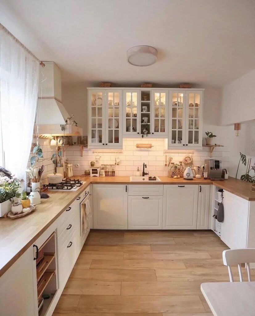 White L-shaped kitchen with glass cabinets and wooden floors