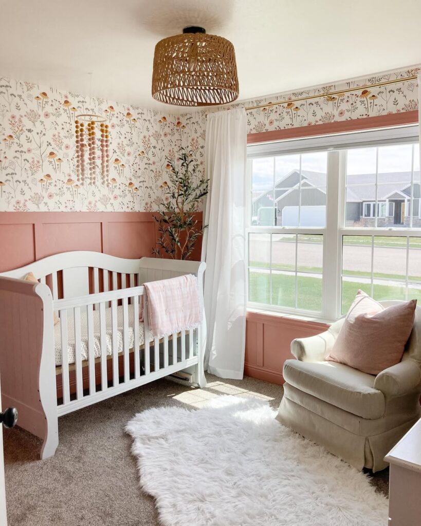 Pink nursery with floral wallpaper white crib and woven ceiling light