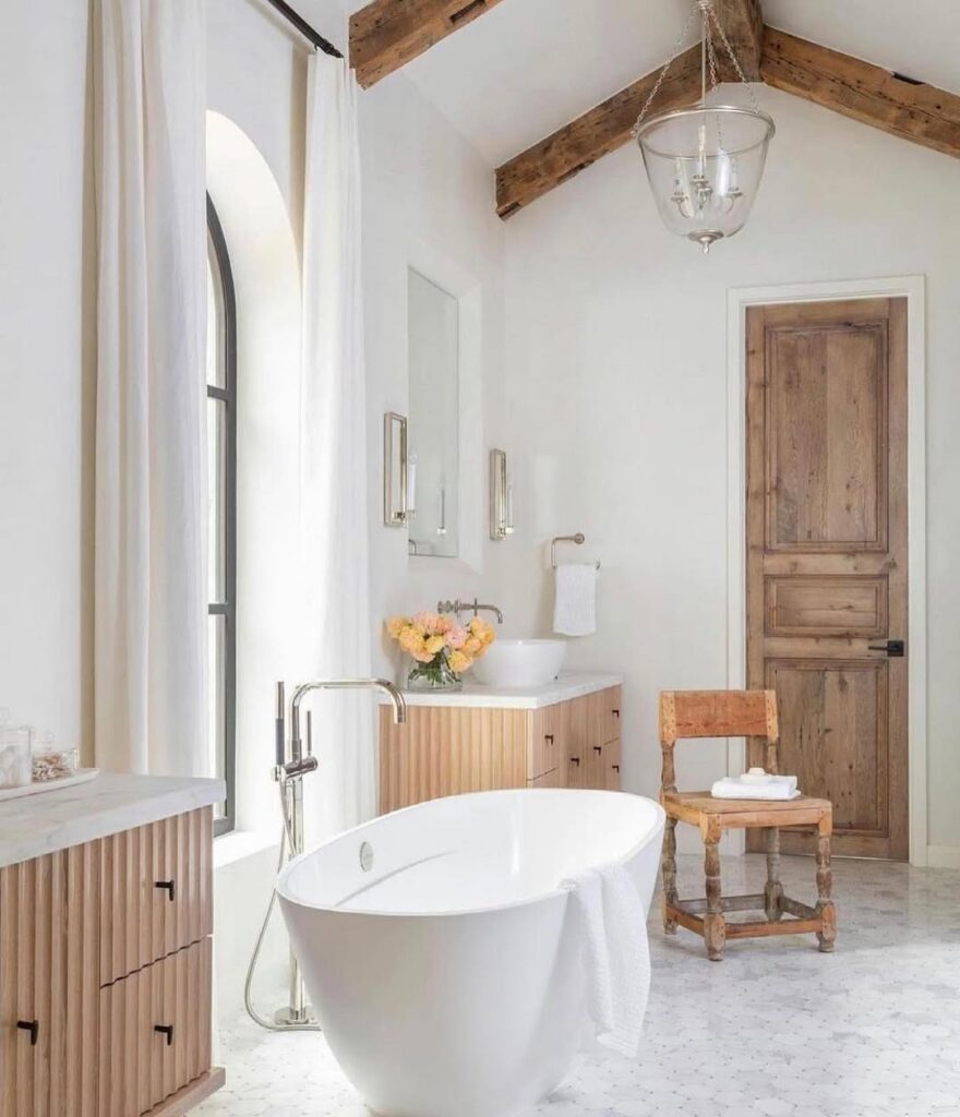 White bathroom with wooden beams and freestanding tub