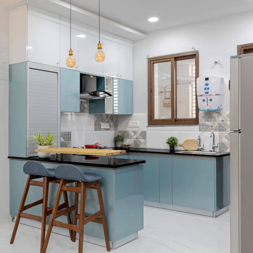 Compact blue kitchen with wooden breakfast bar and modern lighting