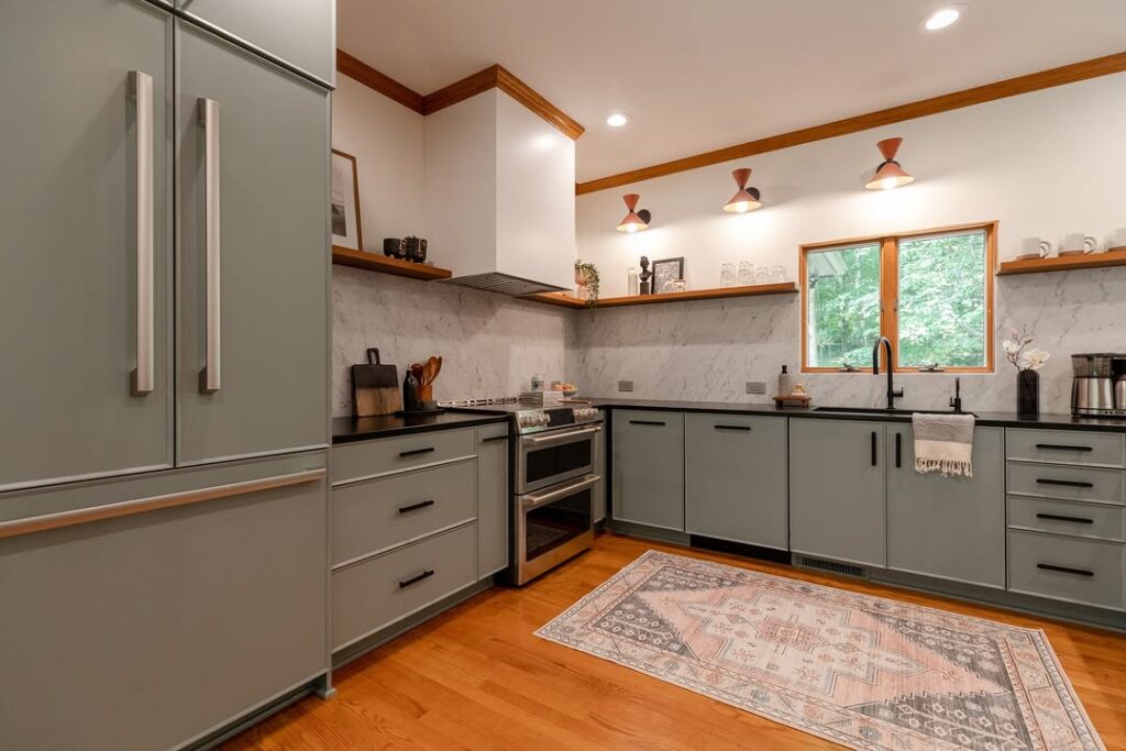 Kitchen with sage cabinets wooden trim and marble backsplash